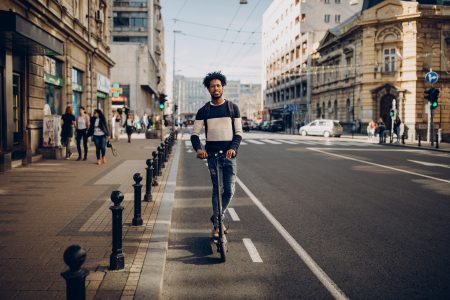Young man riding electric scooter